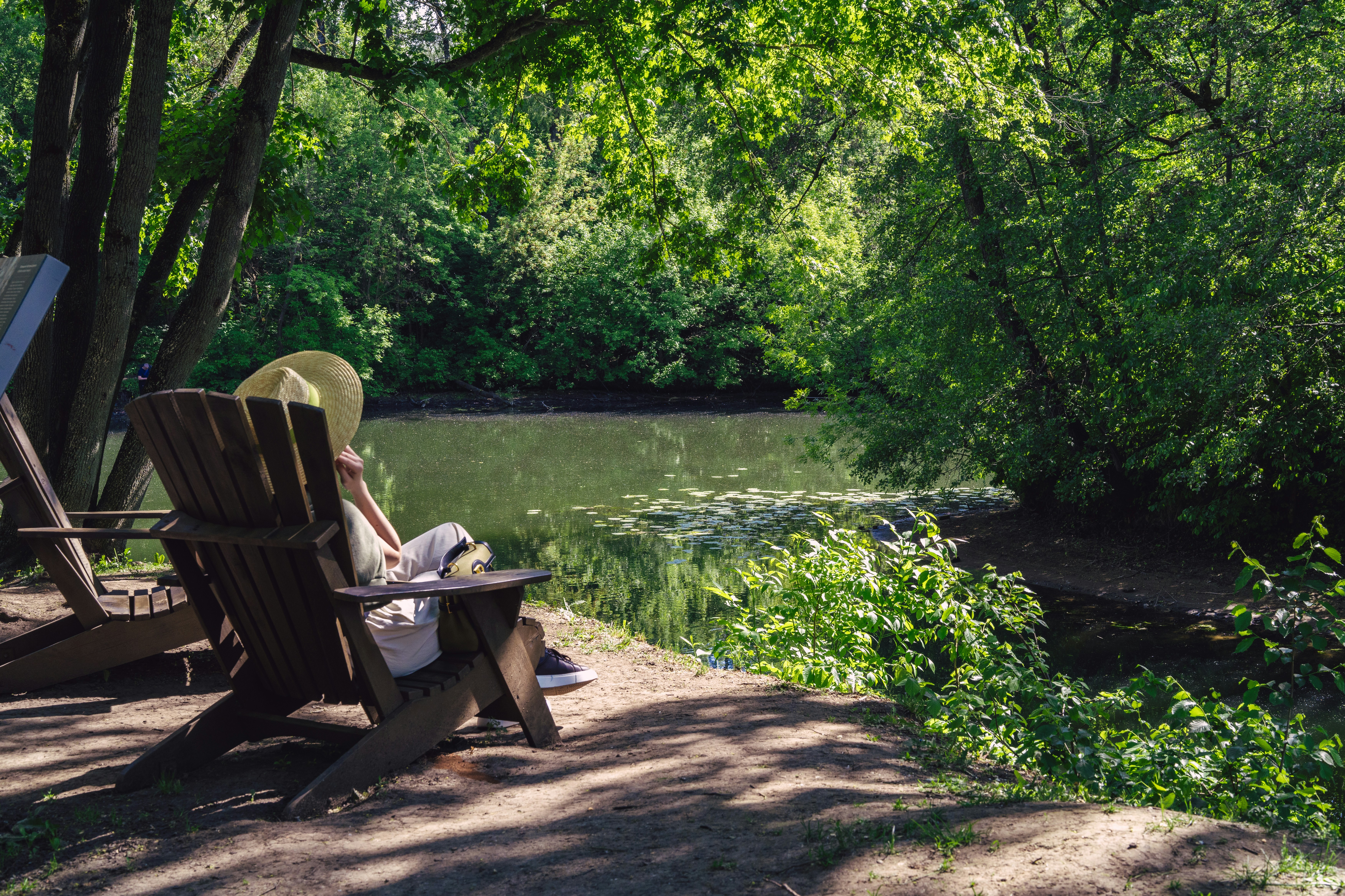 Woman relaxes in a chair by the water.