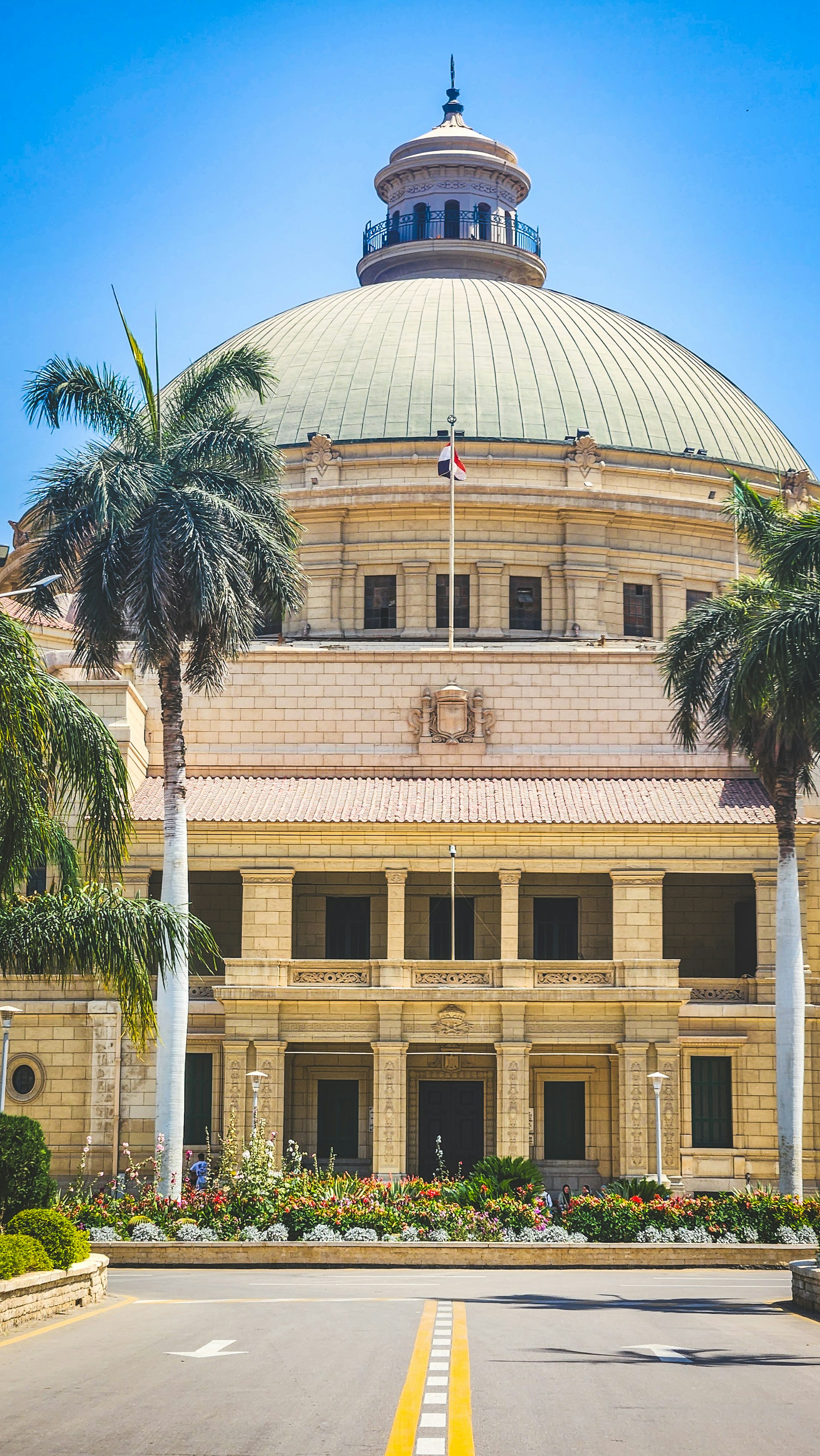 Large building with a dome and palm trees.