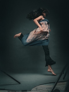 A woman leaps and jumps in a stylish dress.