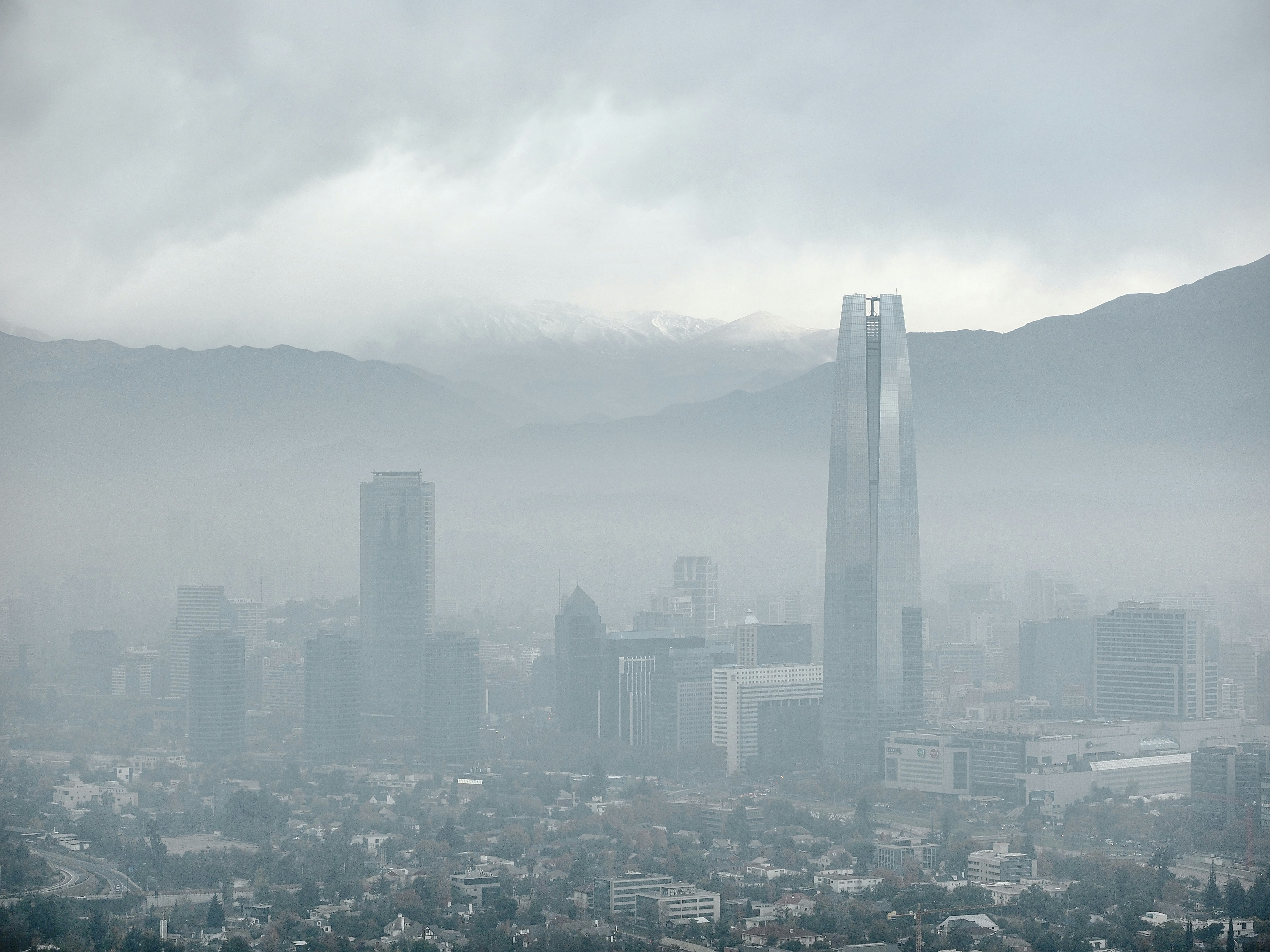 Skyscrapers loom through thick smog and fog.