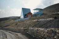 A modern building perched on a rocky hillside