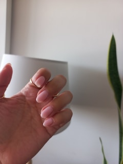 Hand with manicured nails is shown.