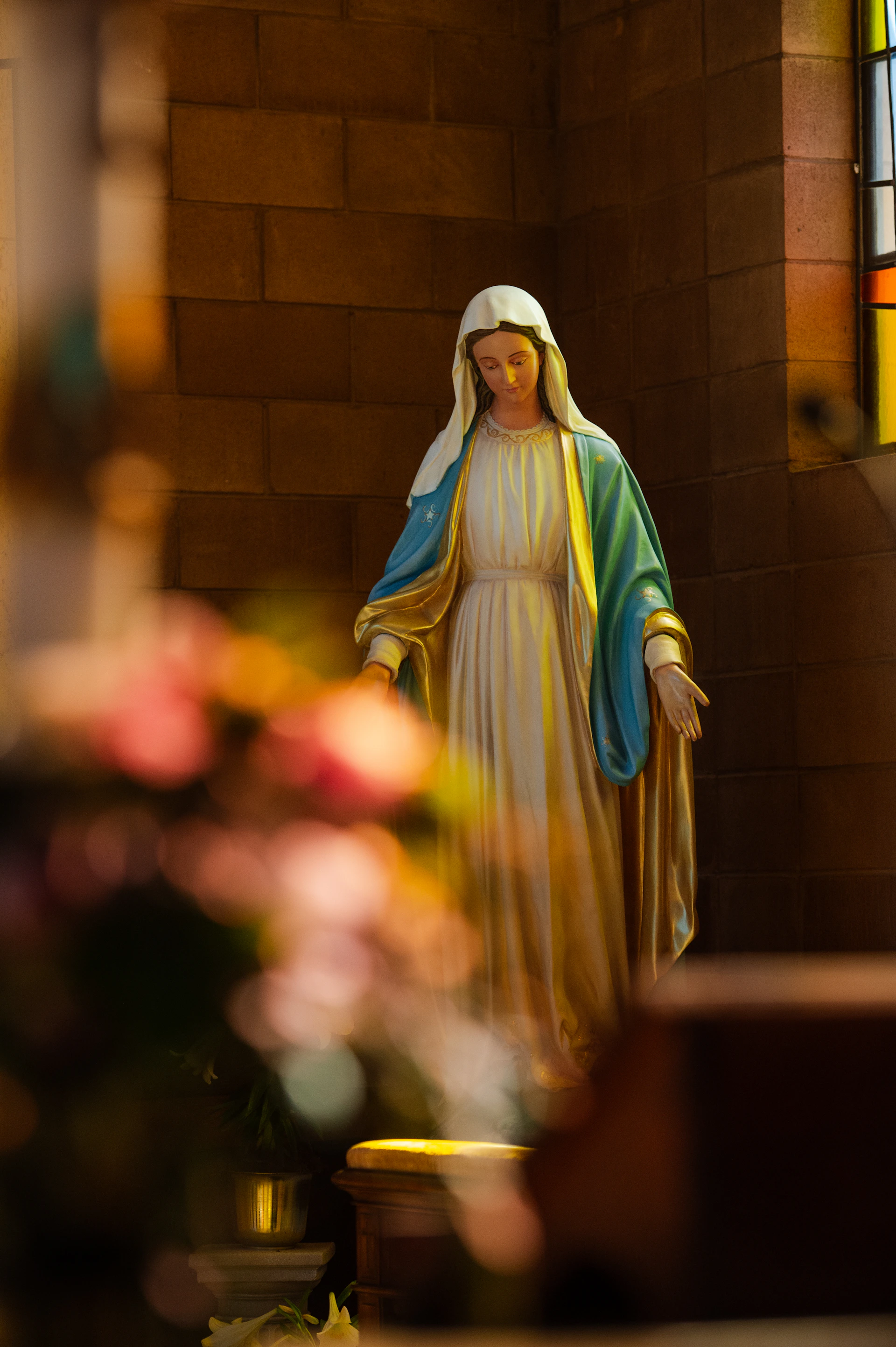 Statue of mary stands in a church interior.