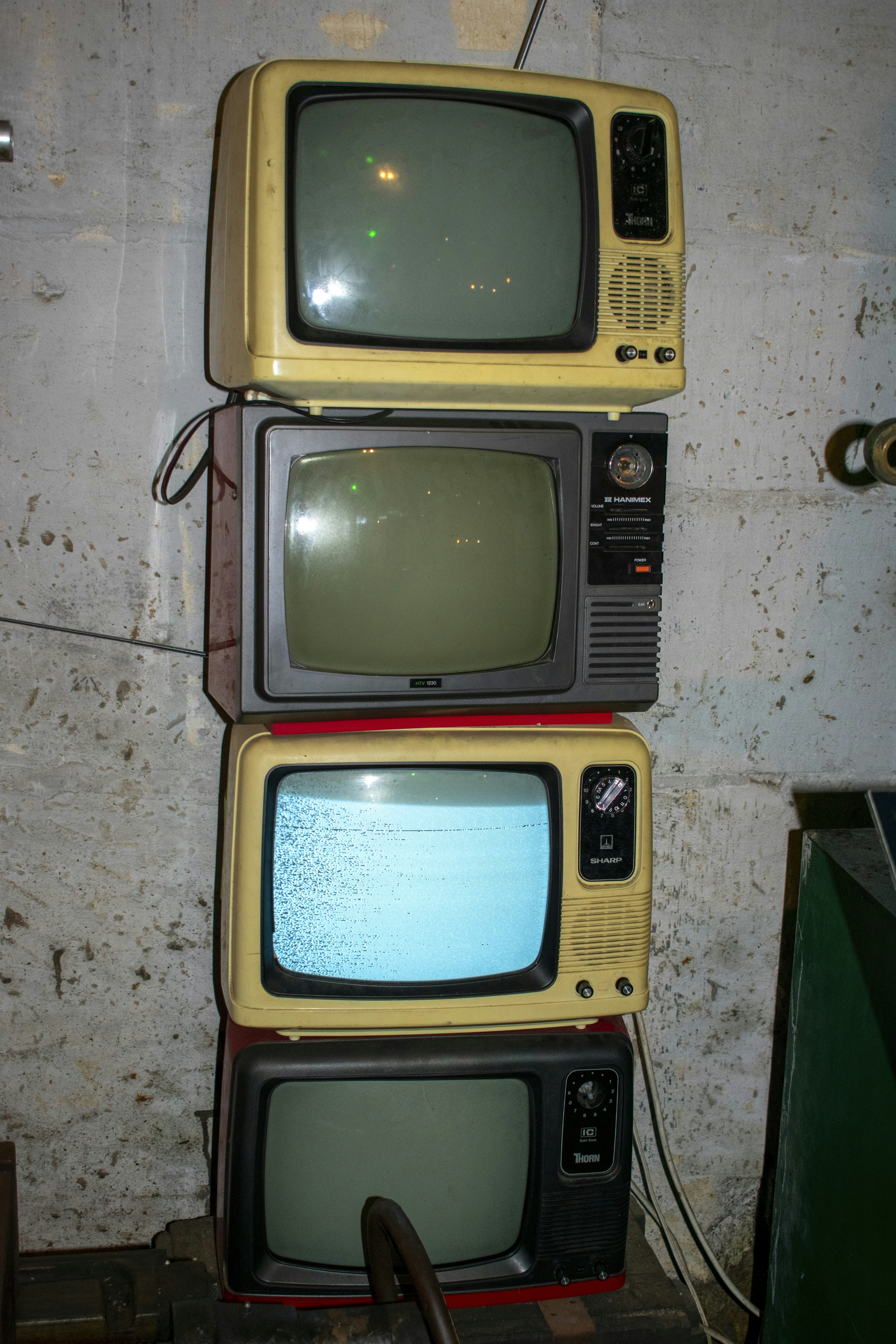 Four old television sets are stacked vertically.