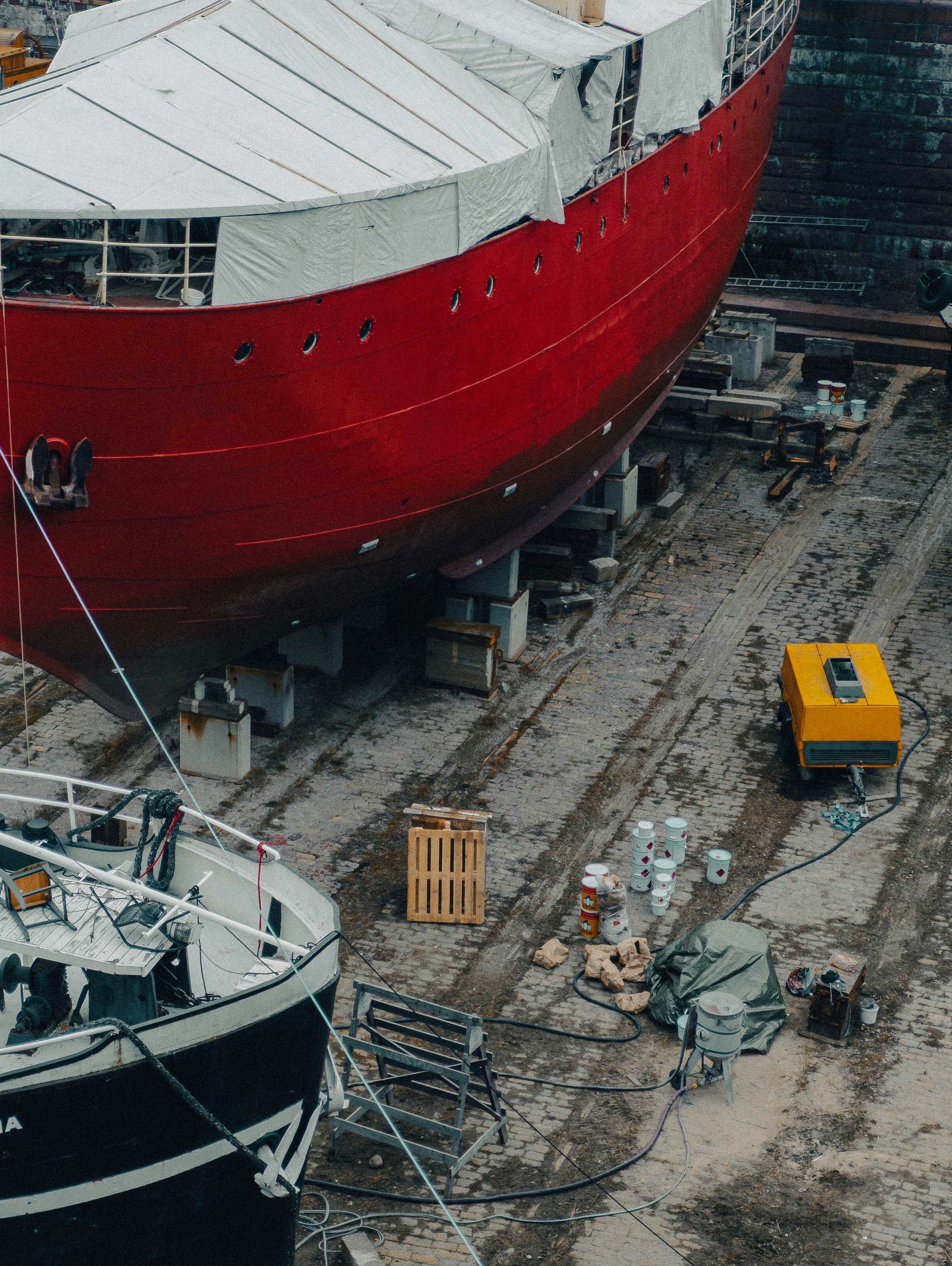A red ship is in drydock for repairs.