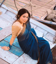 Woman in a saree sits on a boat