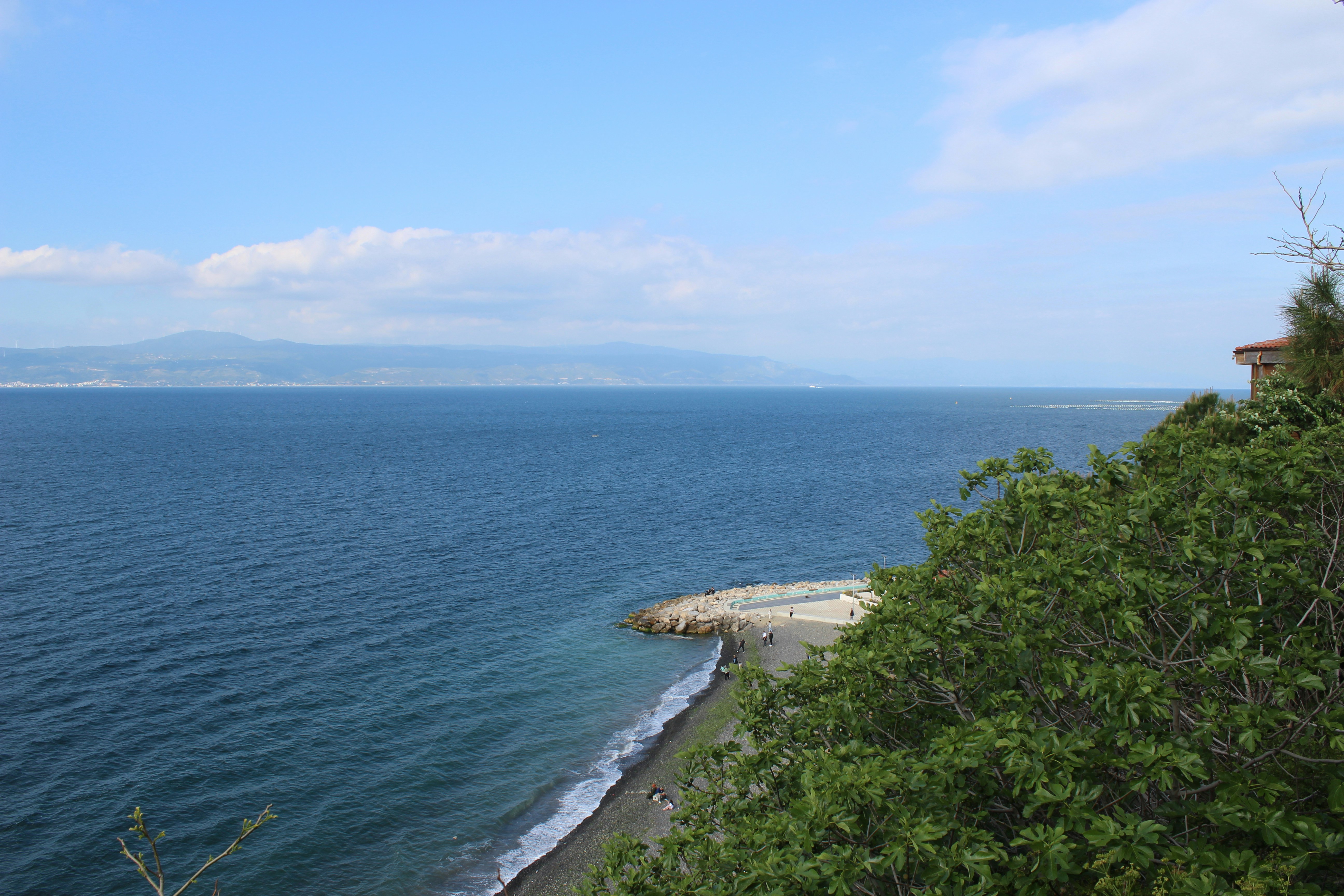 Ocean view with a rocky shoreline and clear blue sky.