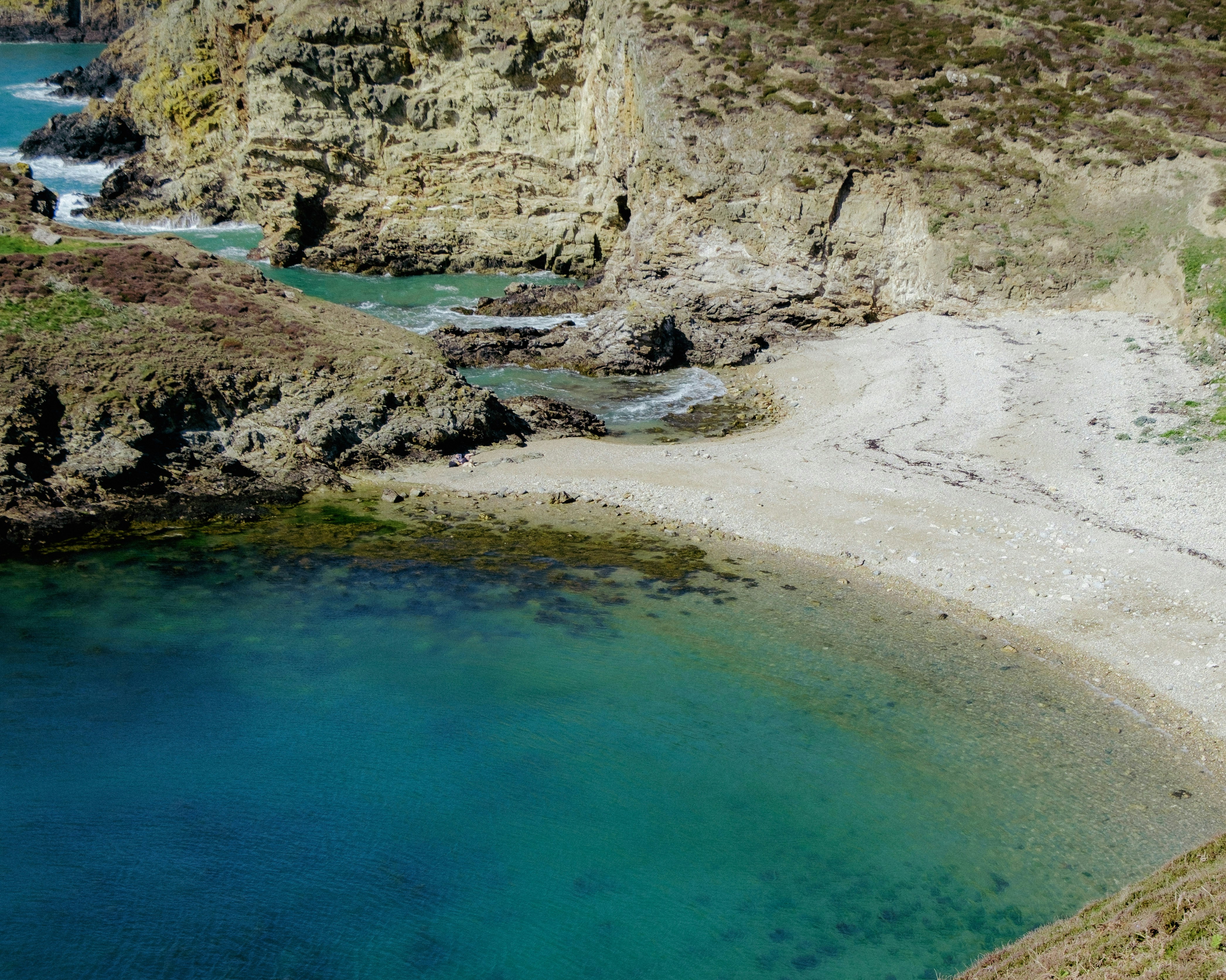 A small beach sits beside turquoise water.