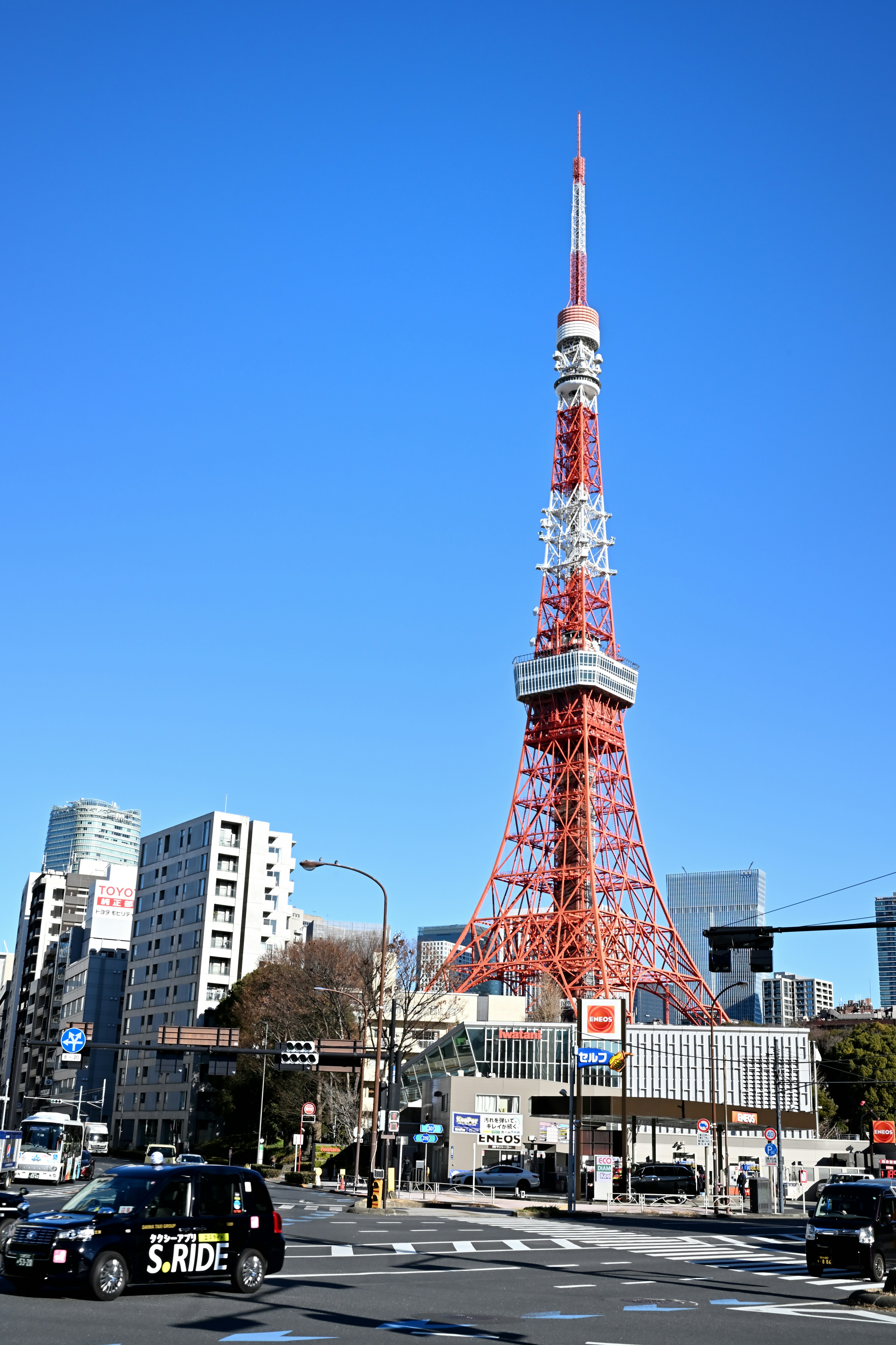 Tokyo tower stands tall against a bright blue sky.
