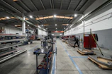 Inside a large factory, equipment and workers are present.