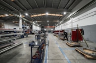 Inside a large factory, equipment and workers are present.