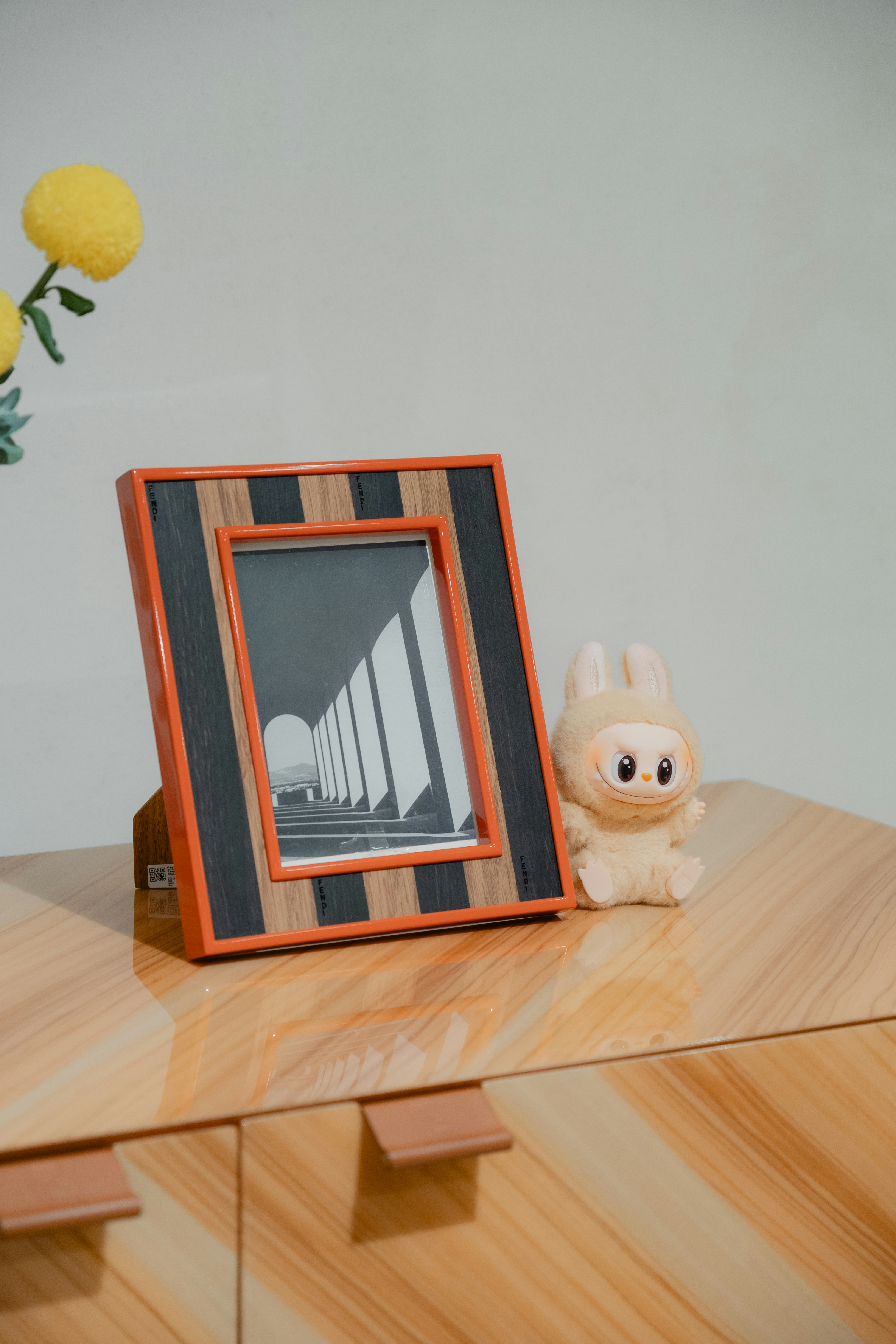 A picture frame and figurine sit on a wooden cabinet. photo – Free Wood ...