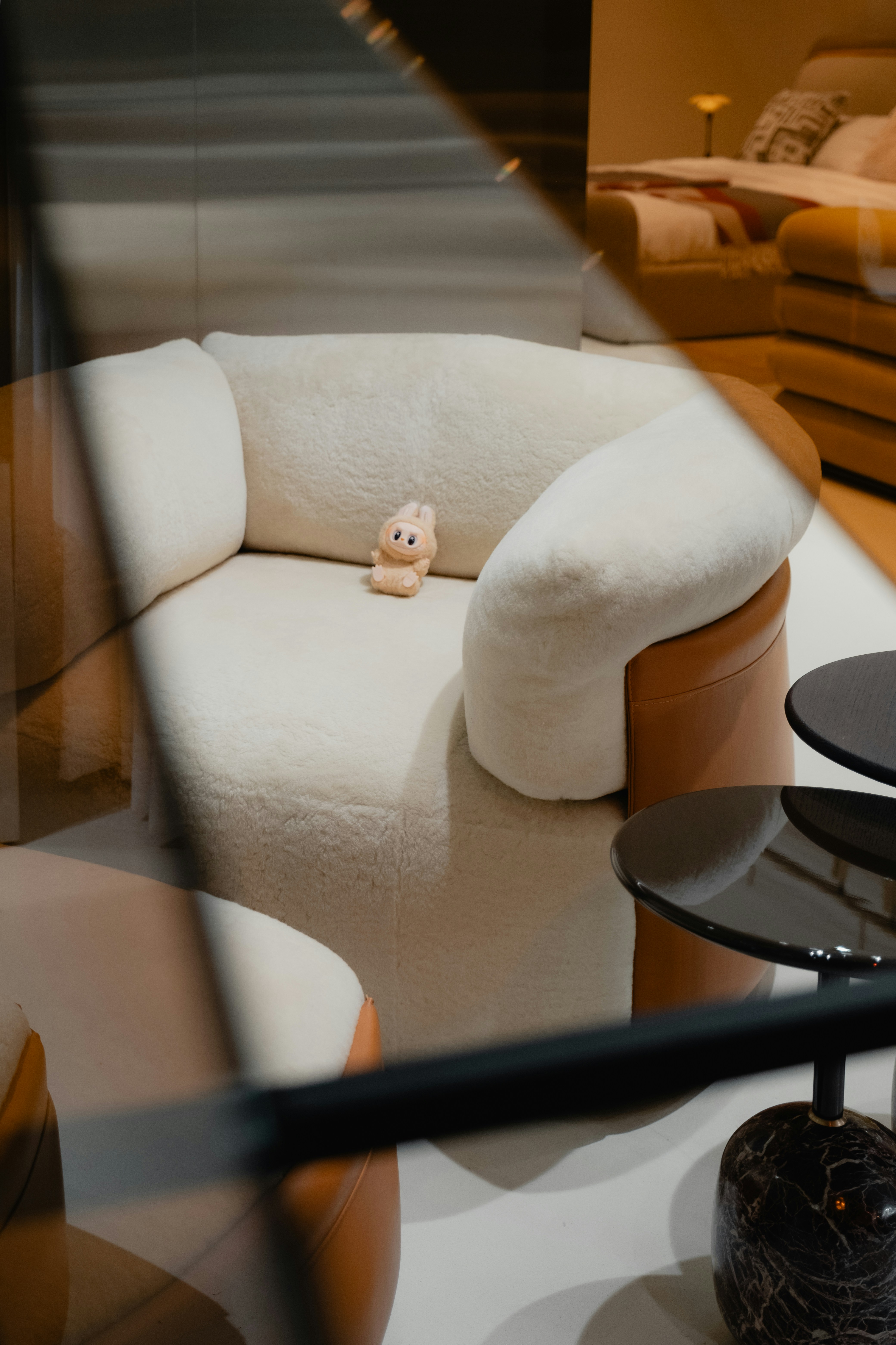 A toy sits on a plush, curved chair.