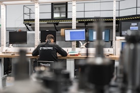 A worker is concentrating at multiple computer screens.