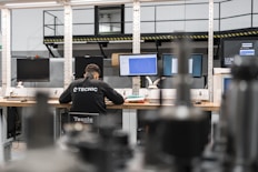 A worker is concentrating at multiple computer screens.