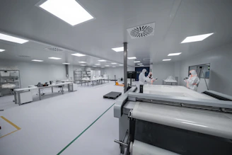 Workers are inside a clean room manufacturing something.