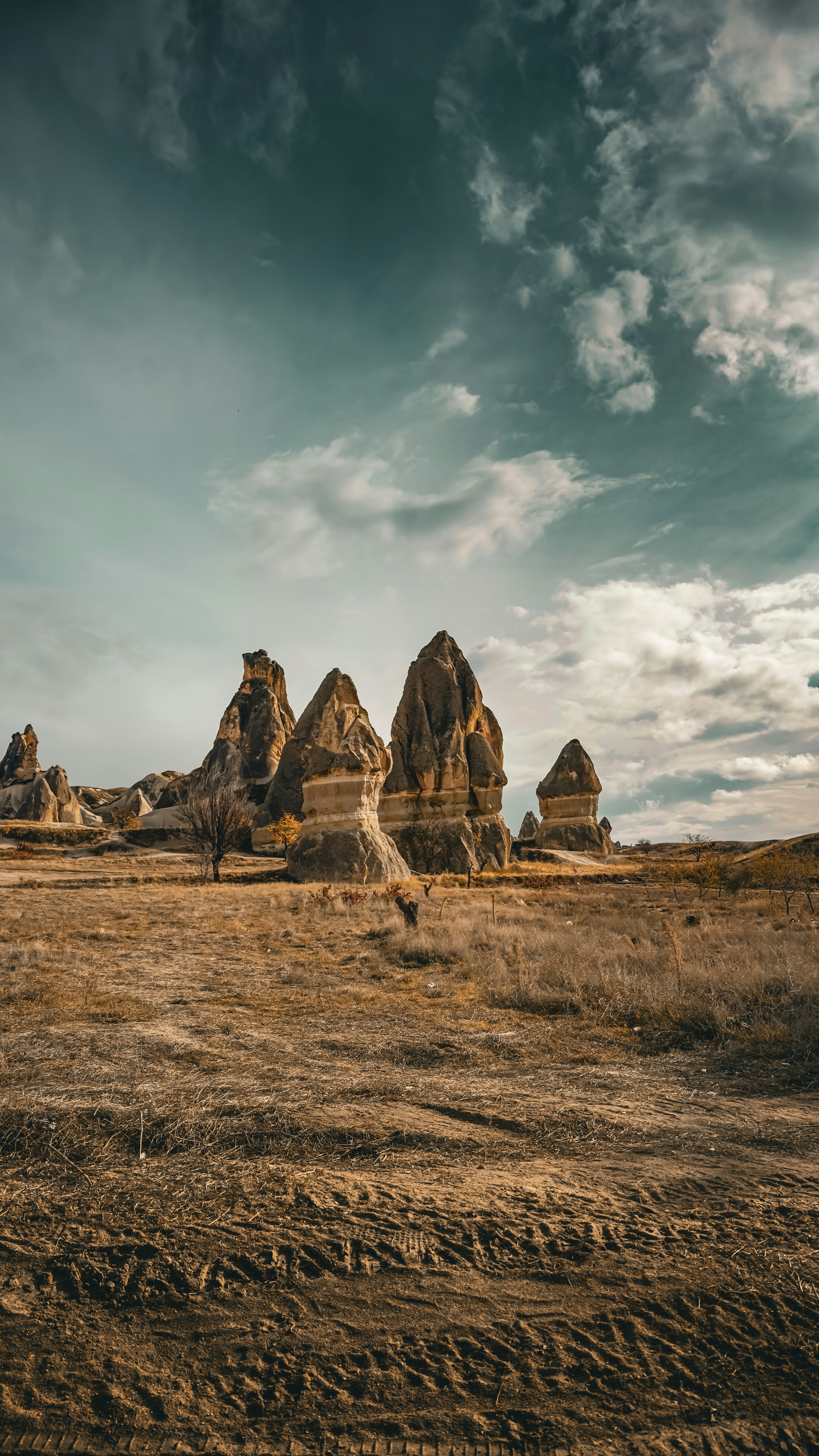 Eroded rock formations stand under a cloudy sky.