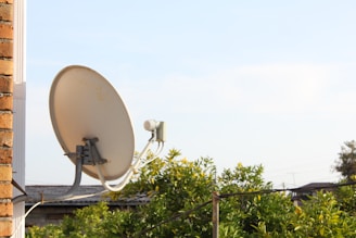 A satellite dish is mounted on a wall.