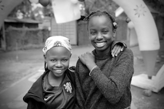 Two smiling girls pose for a photo.