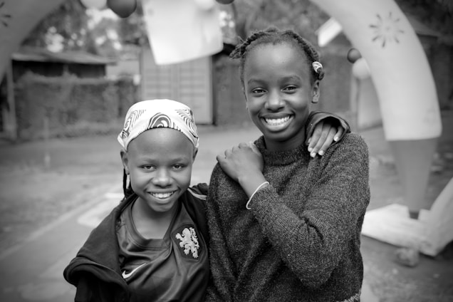 Two smiling girls pose for a photo.