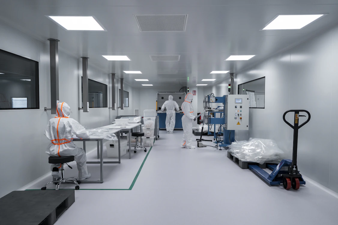 Laboratório estéril com profissionais em trajes de proteção