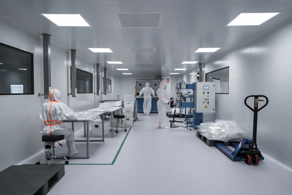 High-tech laboratory setting with professional technicians in white cleanroom suits handling delicate microelectronics