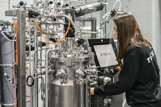 A woman operates complex scientific equipment.