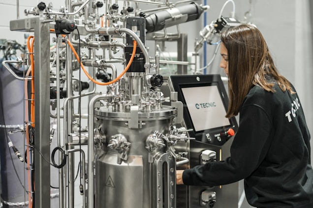A woman operates complex scientific equipment.