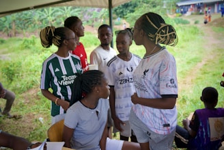 A group of young people stand together outside.