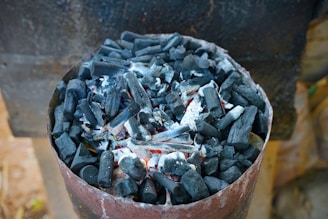 Burning charcoal inside of a metal container.