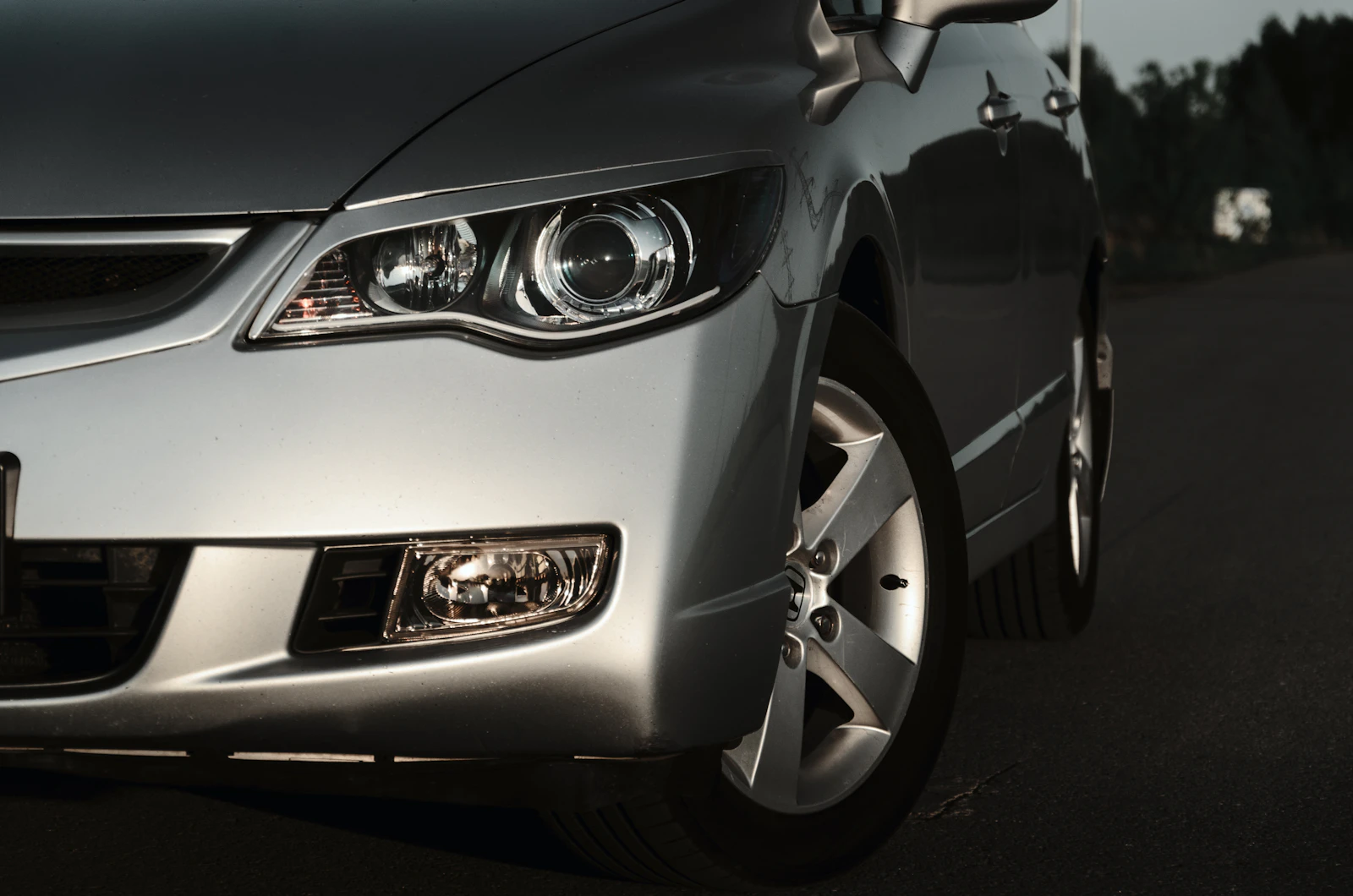 A car's clean front bumper and fender after body work, no damage