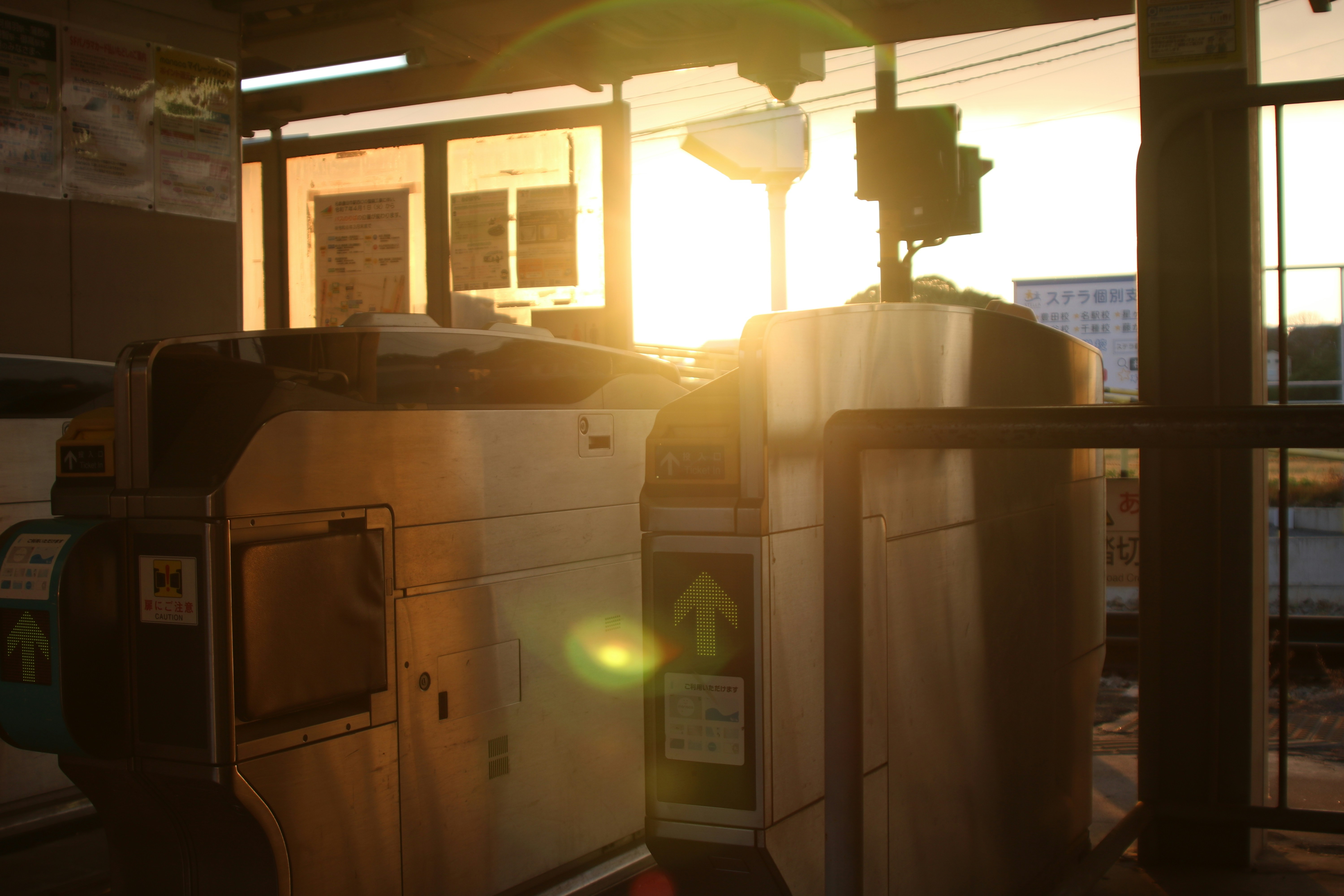 Sunlight streams through a train station's turnstiles.