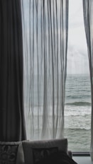 Ocean view through sheer curtains.