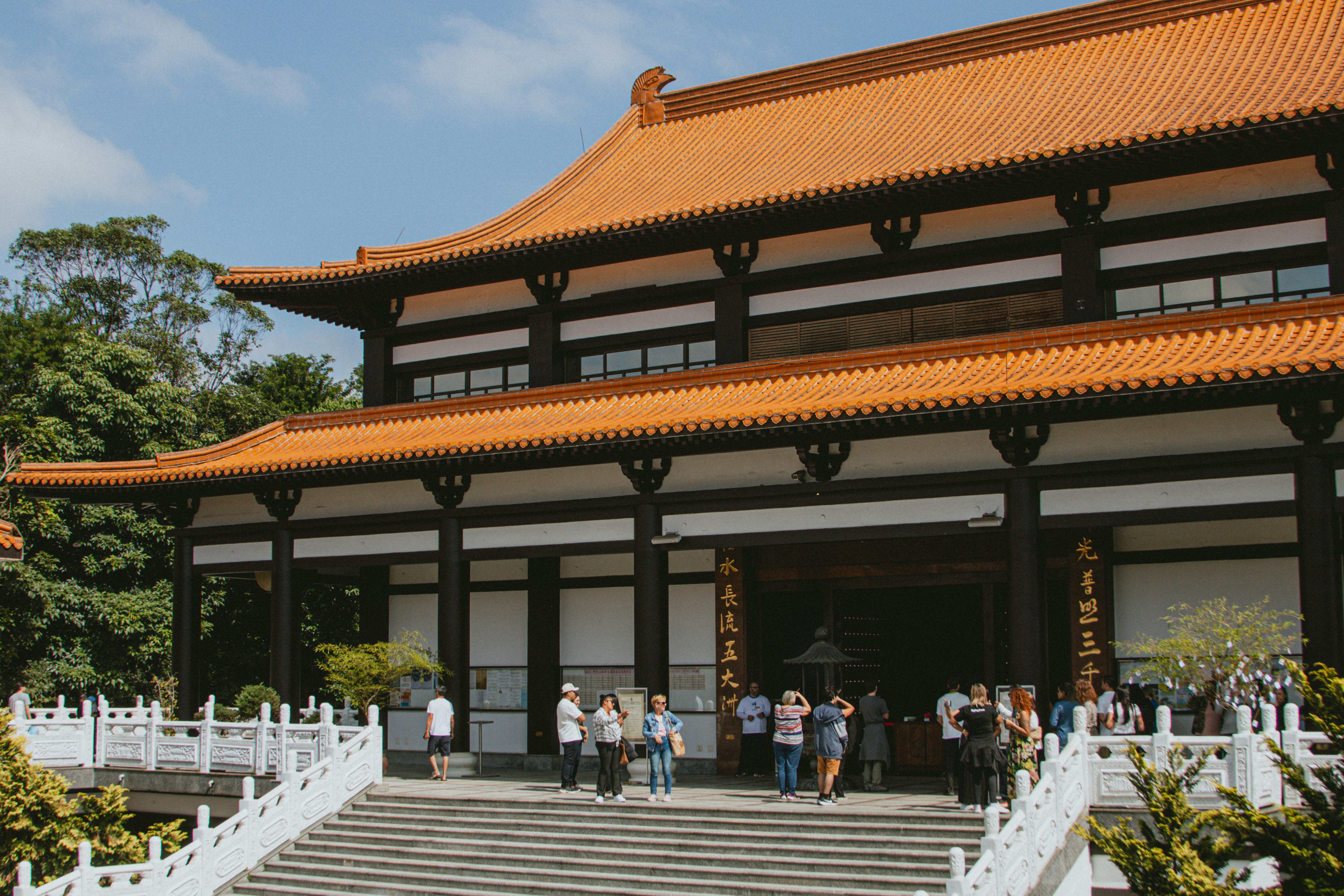 Buddhist temple with a red roof and visitors.