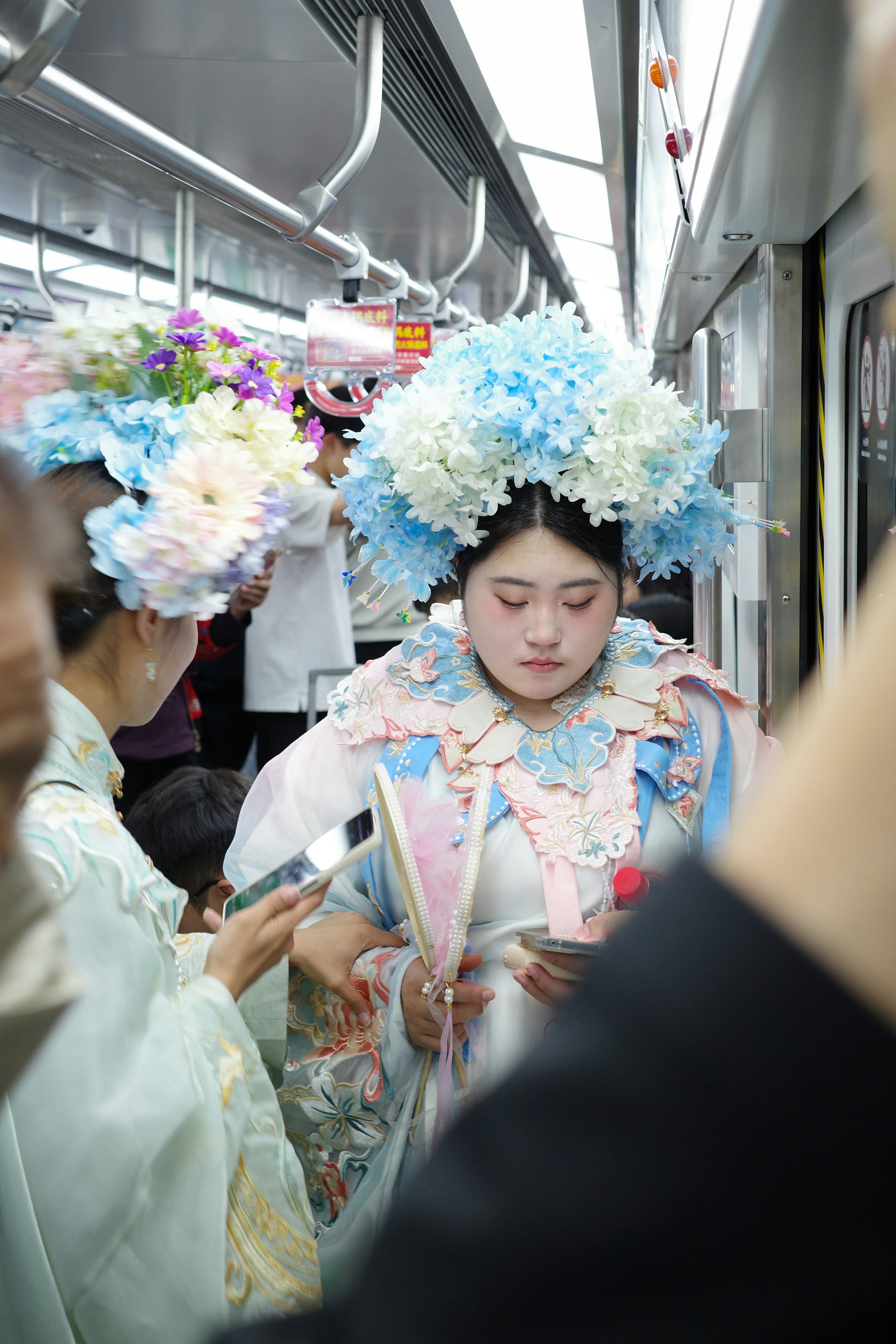 People in elaborate costumes ride the subway.