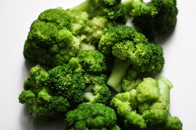 Here is a sentence describing the image: fresh broccoli florets are seen close up.