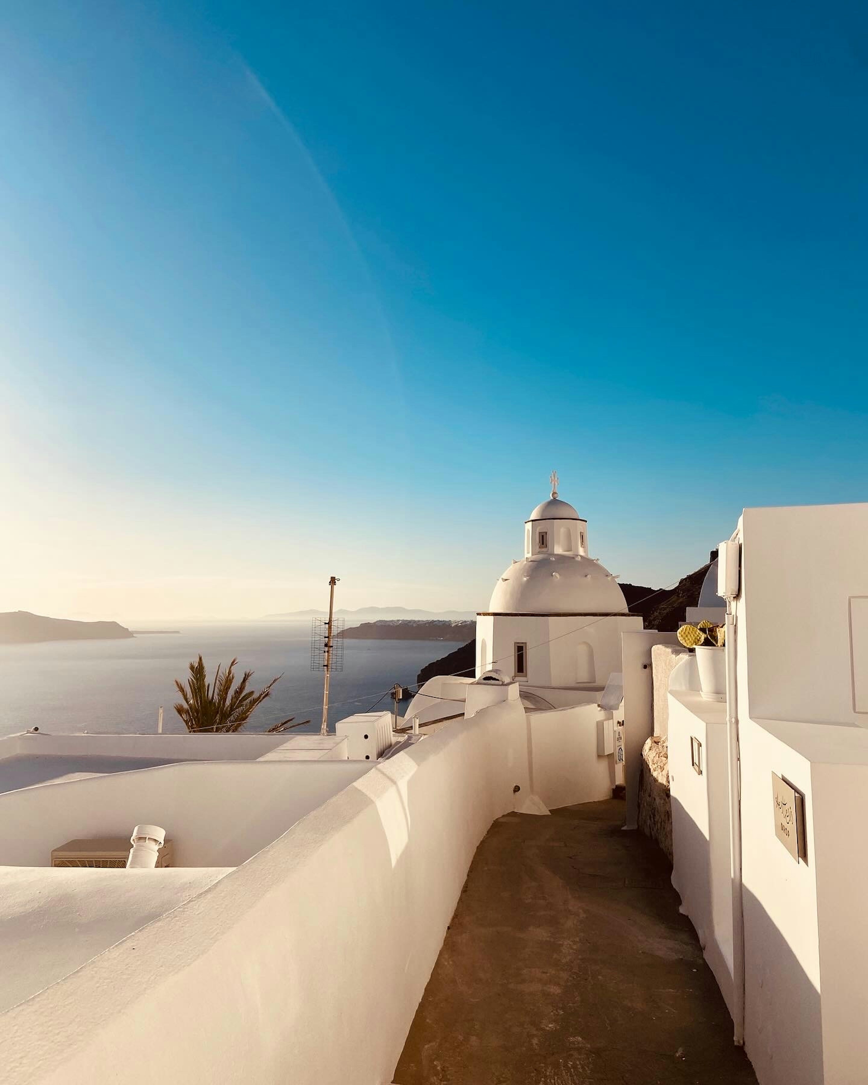 White buildings and a church overlook the sea.