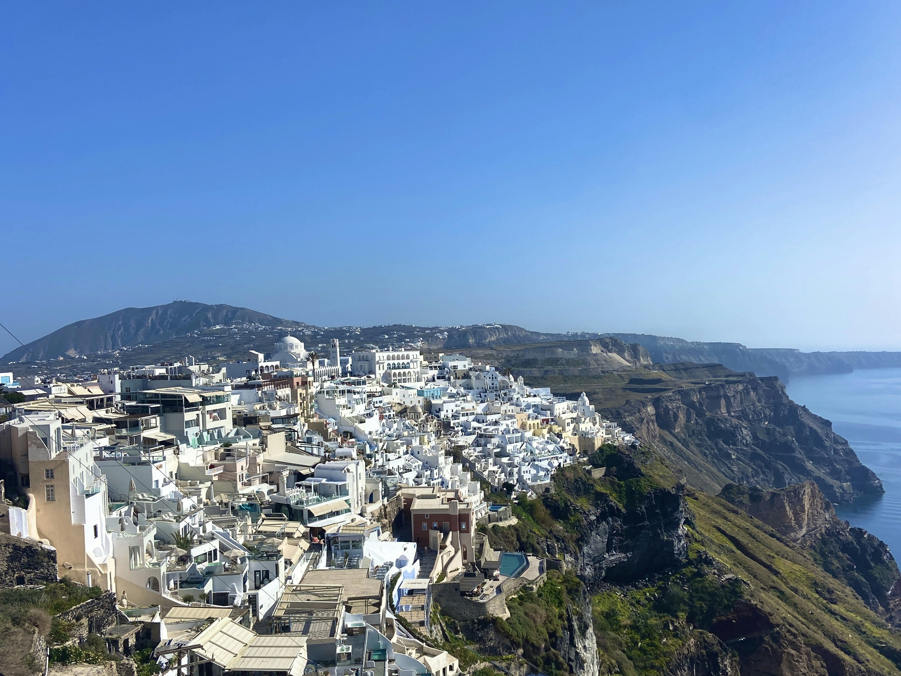 White buildings line the coast of santorini.