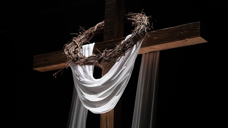 A cross, crown of thorns, and white cloth.