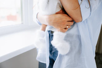 A mother holds a baby with soft socks.