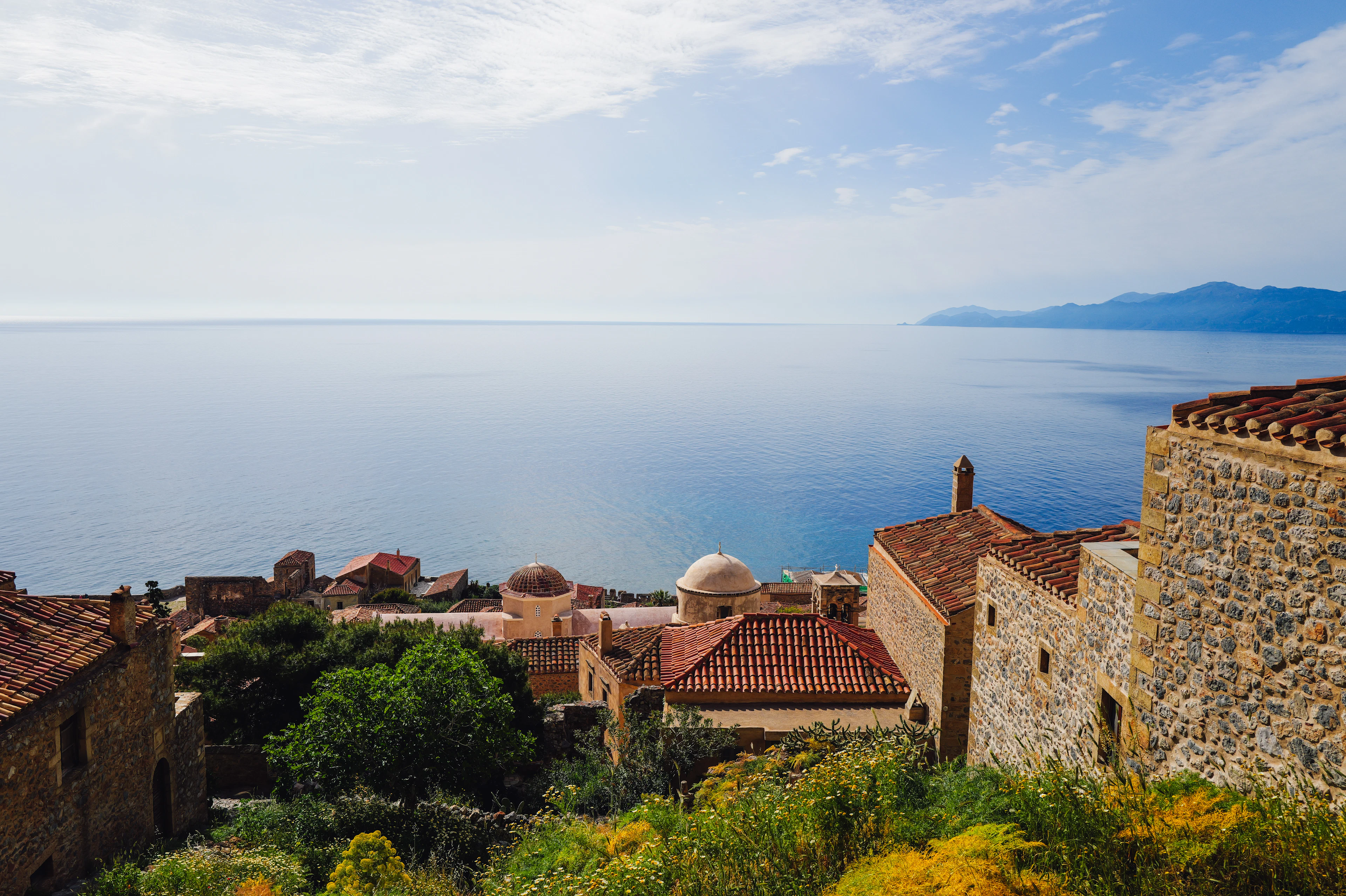 Stone houses and tiled roofs above the sea in an old walled town on a rock