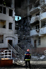 Firefighter surveys the destruction of a building.