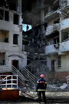 Firefighter surveys the destruction of a building.