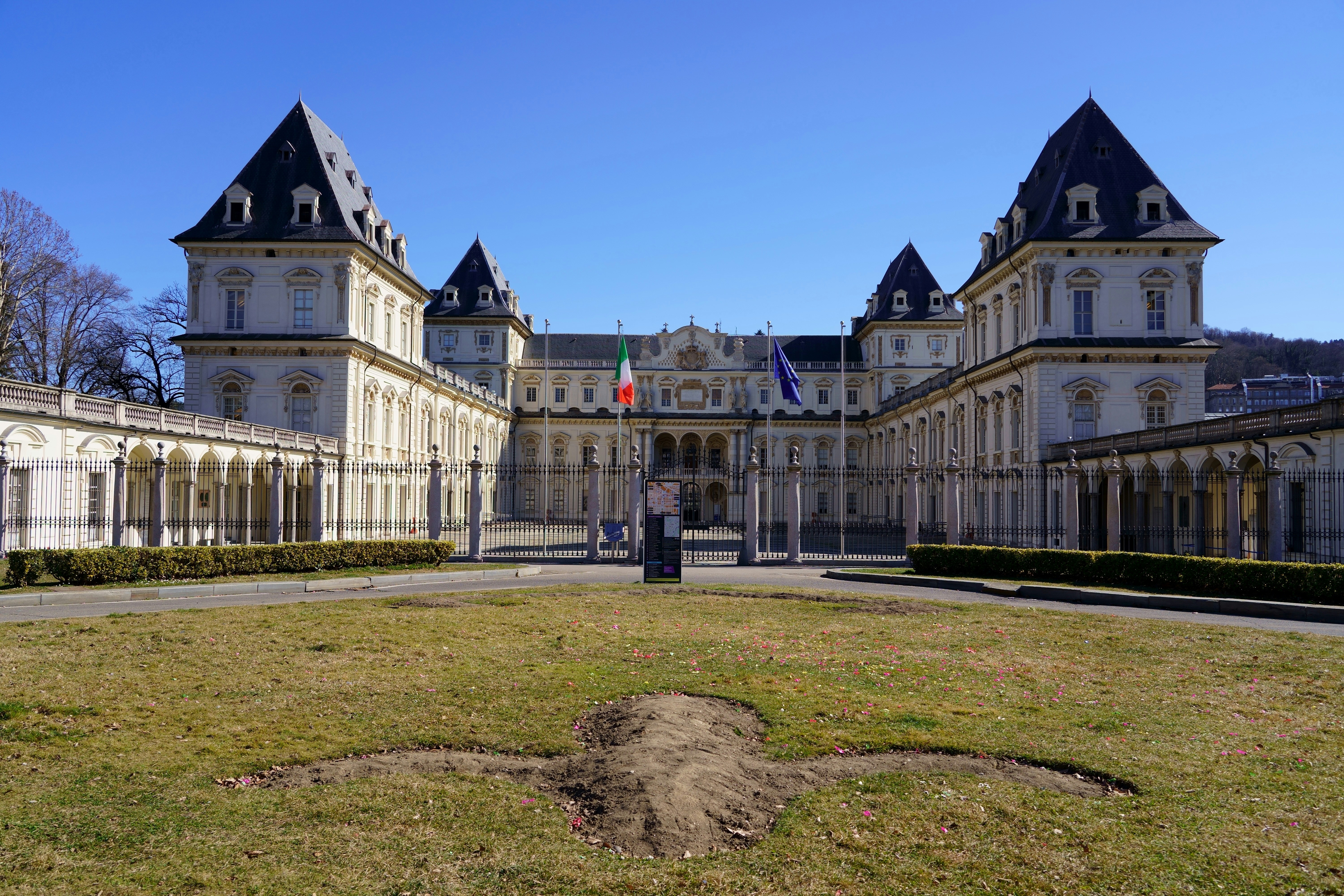 An impressive italian palace stands under a blue sky.