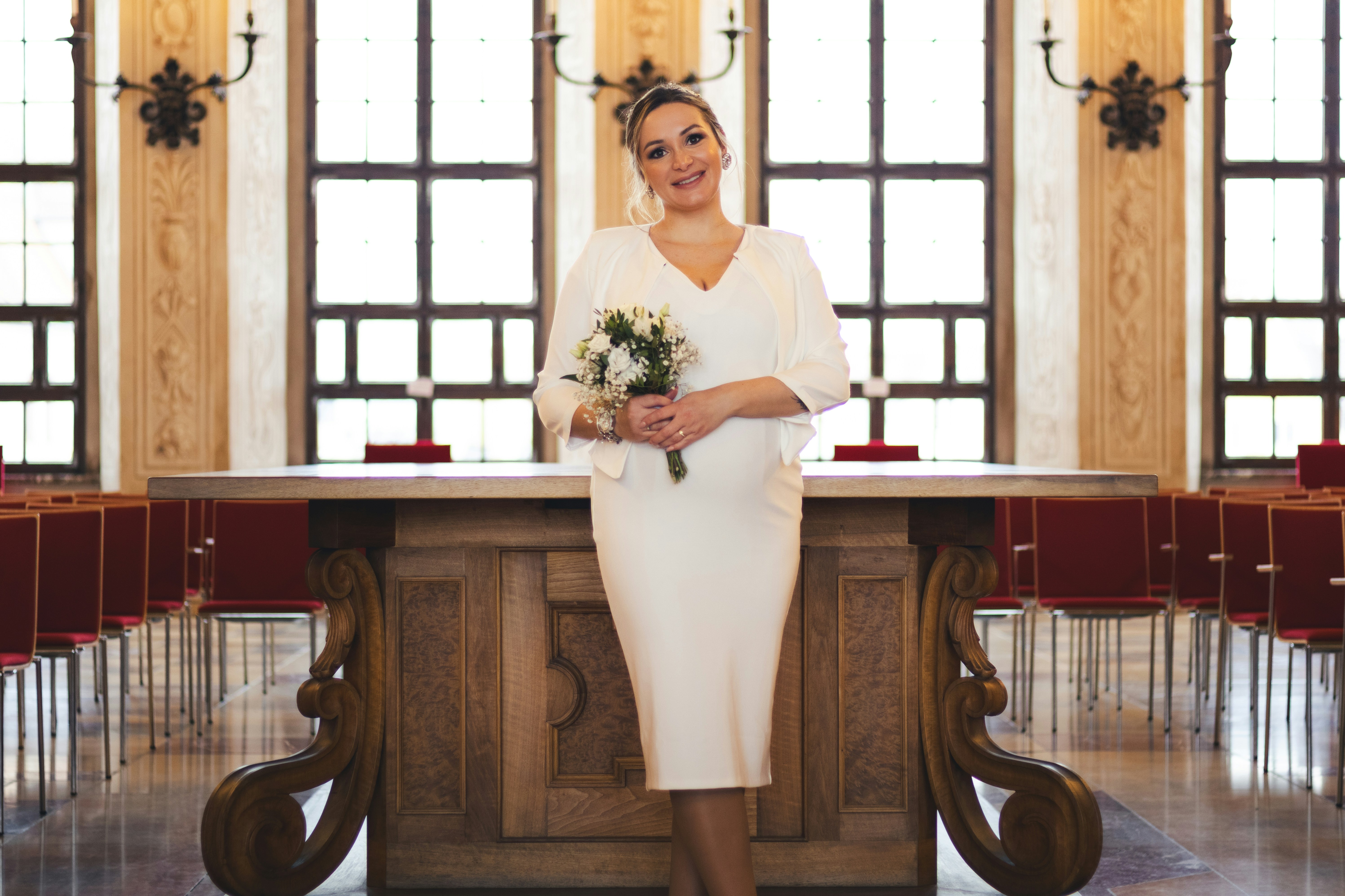 Bride posing in front of a wooden table.