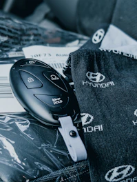 A hyundai car key rests near branded accessories.