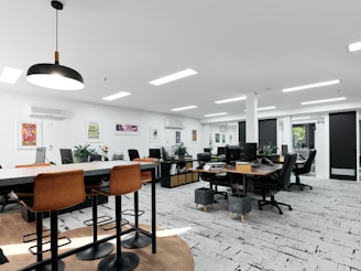 A modern office space with tables, chairs, and desks.