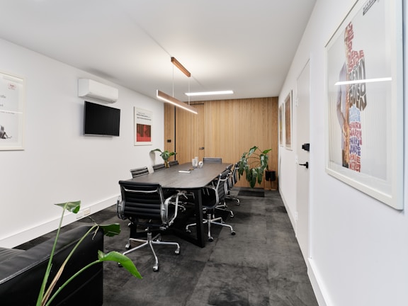 A modern meeting room with long table and chairs.
