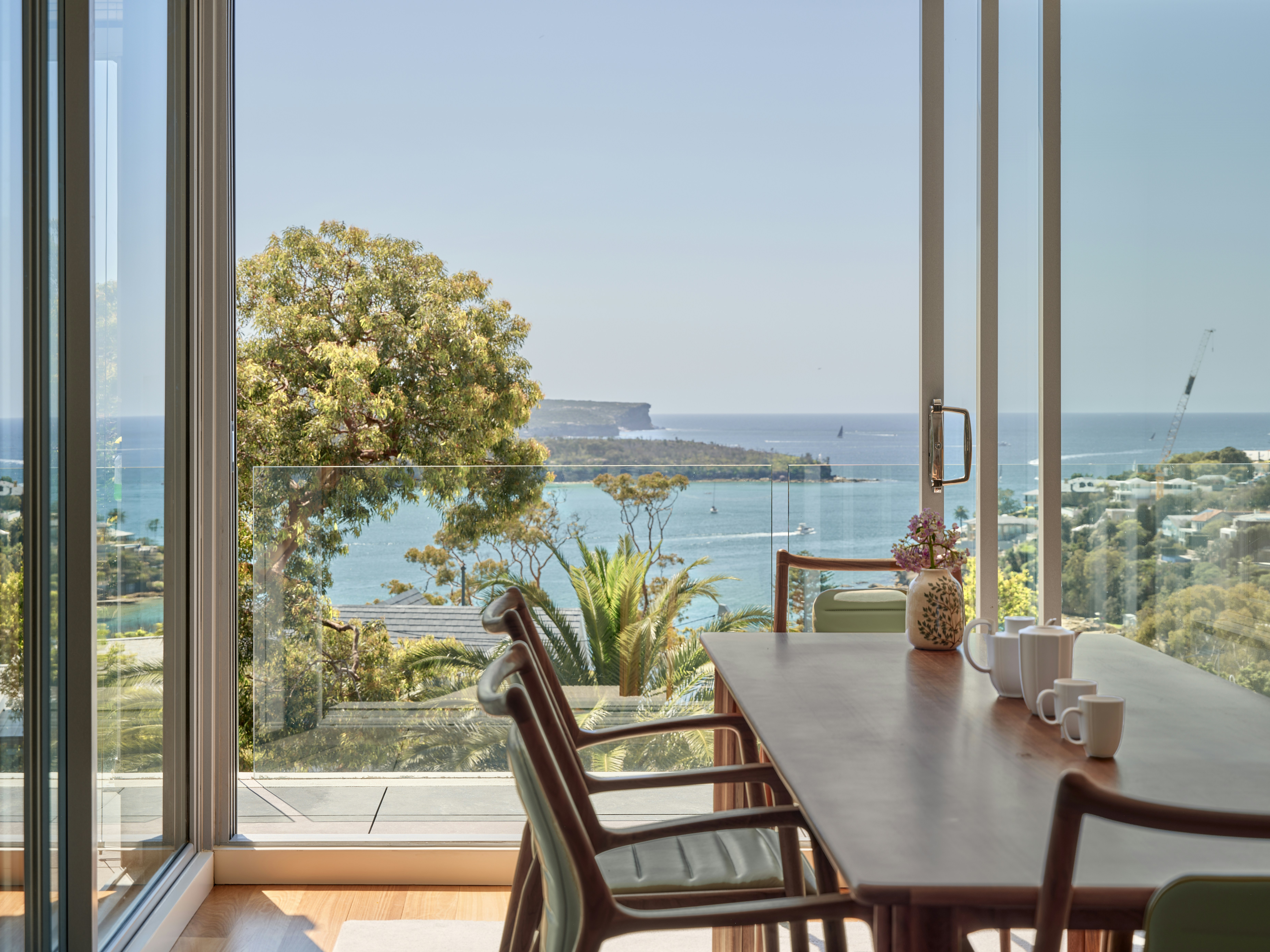 Dining room with ocean view through large glass doors.