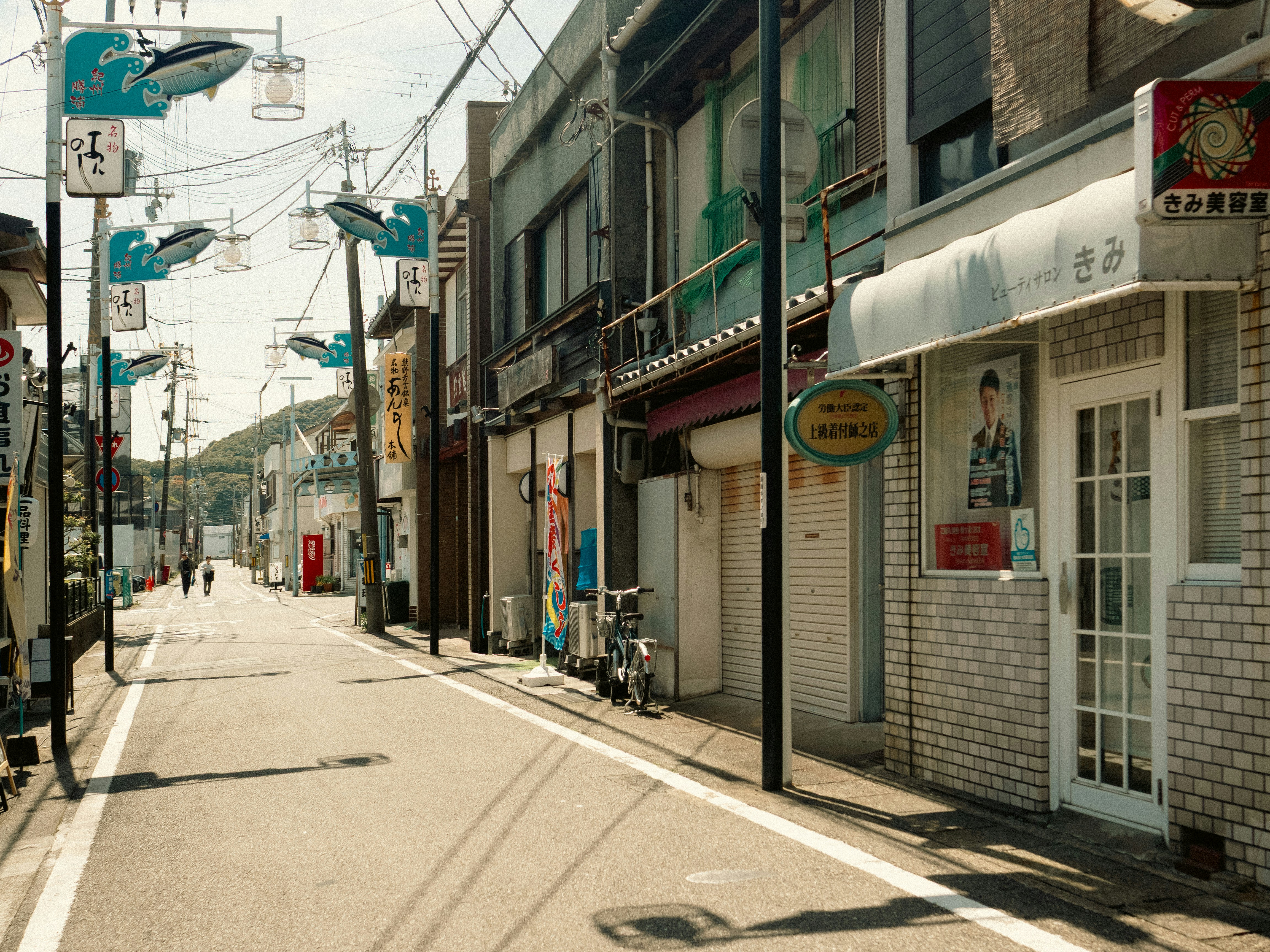 A quiet street in japan, lined with shops.